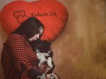 Na drugim zdjęciu jest klęcząca kobieta przytulająca psa, w tle jest poduszka w kształcie serca z napisem „Kocham Cię” na podłodze leżą balony.